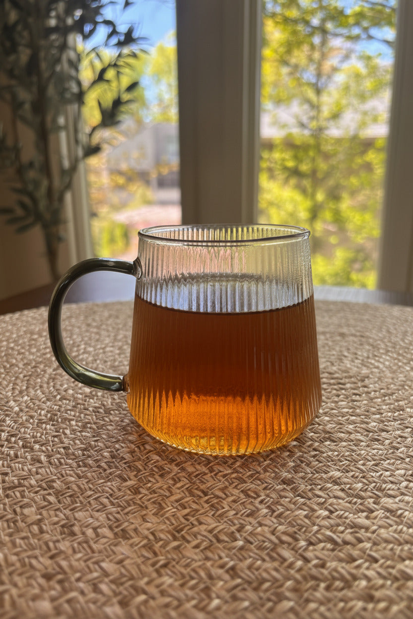 glass mug containing the tea with a rich warm golden hue