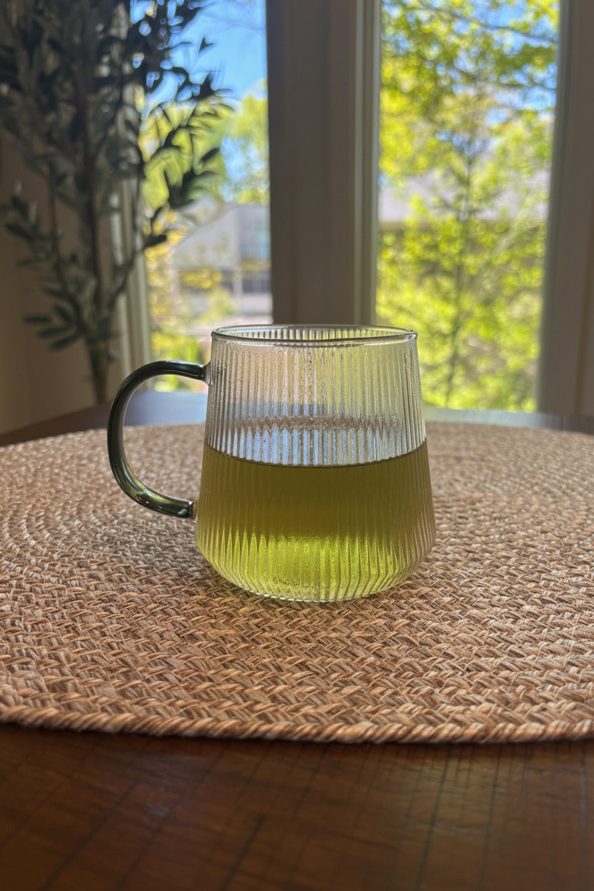 glass cup with tea infusion of a pale green tone.