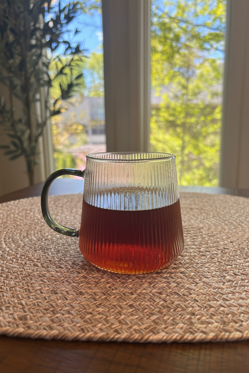glass cup containing a red hued tea